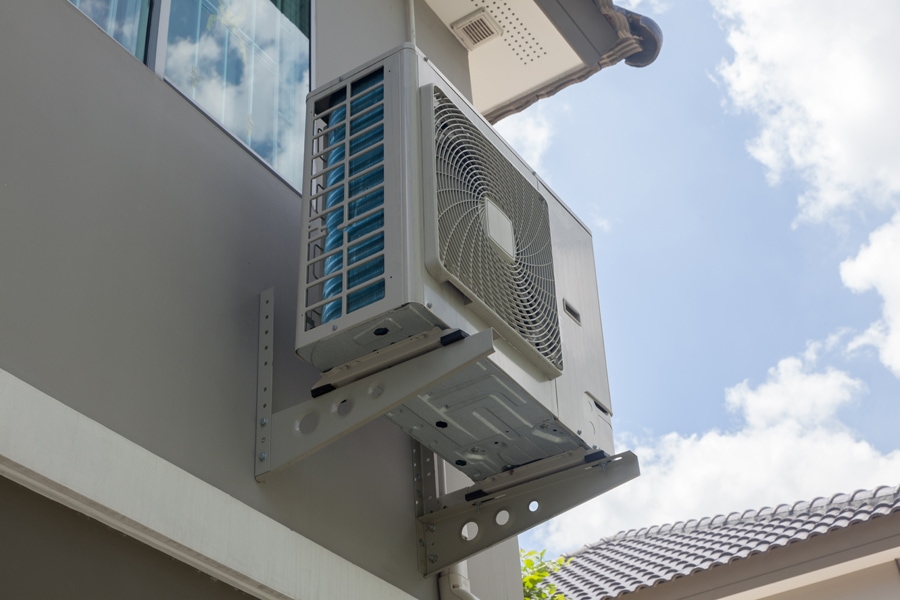 Heat pump shown on the outside of a house.